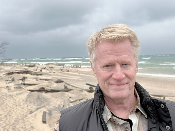 A picture of author John U. Bacon on a stormy beach.